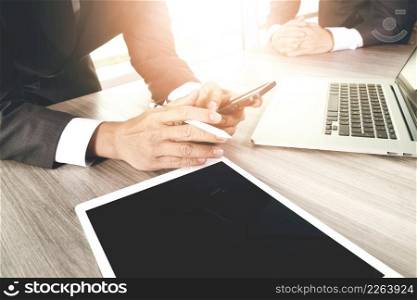 businessman working with digital tablet computer and smart phone and laptop computer with digital business strategy layer effect on wooden desk as concept