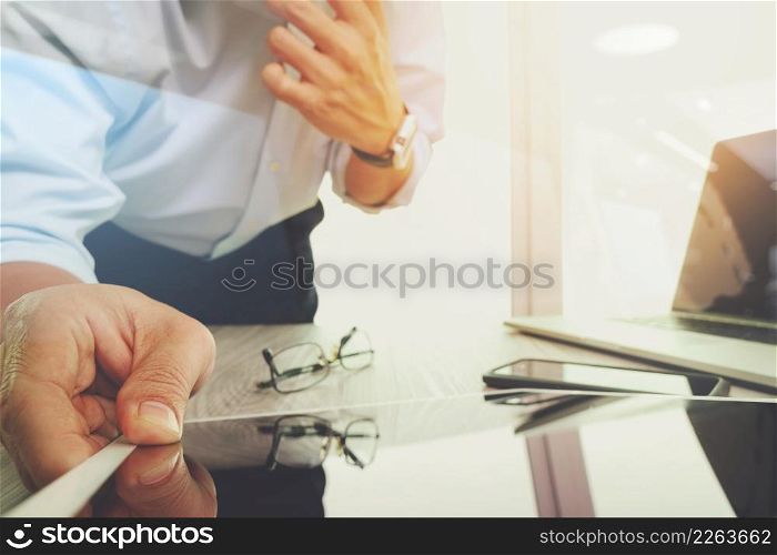 businessman working with digital tablet computer and smart phone with digital business strategy layer effect on wooden desk as concept