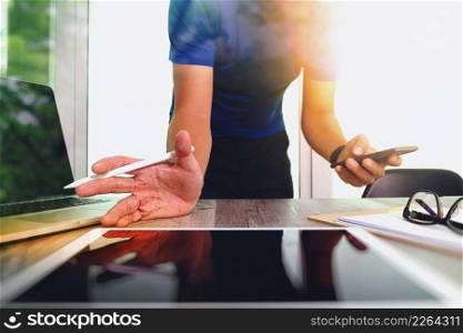businessman working with digital tablet computer and smart phone with digital business strategy layer effect on wooden desk as concept