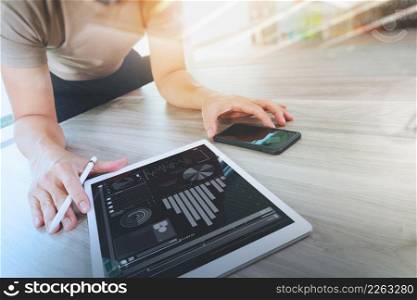 businessman working with digital tablet computer and smart phonewith digital business strategy layer effect on wooden desk as concept