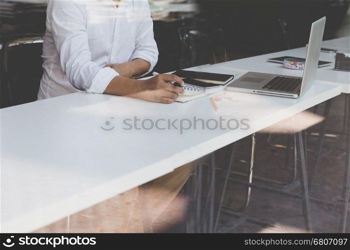 businessman working with document and laptop computer for use as office workplace concept - seen through glass shot