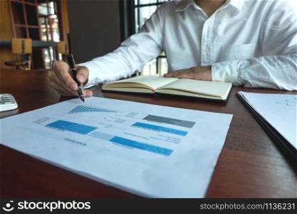 Businessman working with income statement document on the wood table.Business concept.