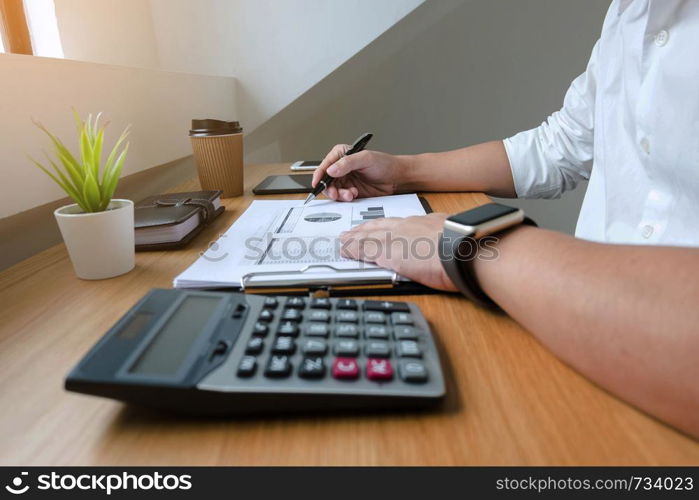 Businessman working with income statement document on the wood table.Business concept.