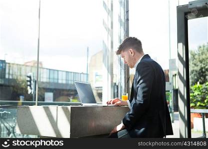 Businessman working with laptop in cafe