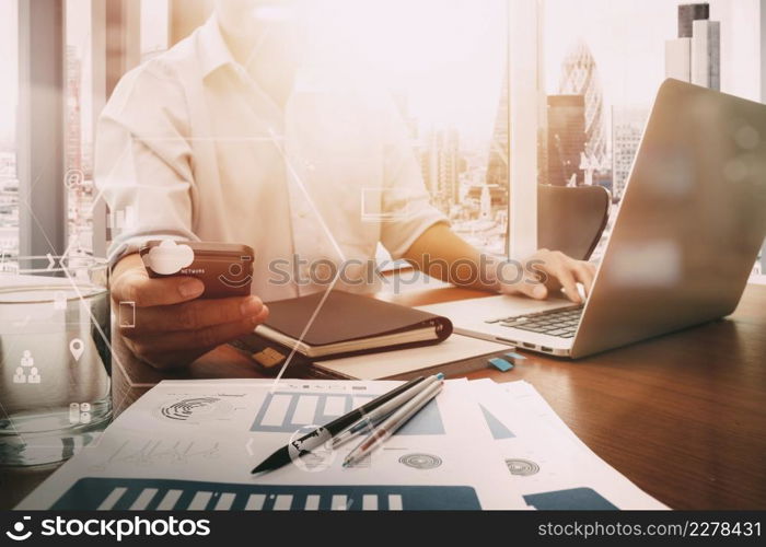 businessman working with mobile phone and digital tablet and laptop computer on wooden desk in modern office with VR icon and chart diagram