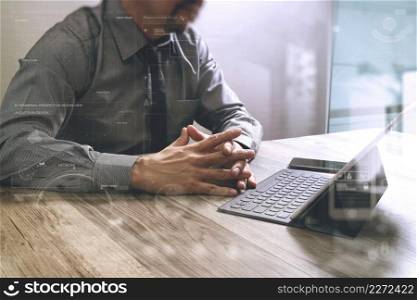 businessman working with new start up project.using smart phone digital tablet docking smart keyboard and laptop computer on wooden desk,sun effect