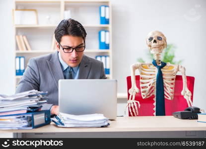 Businessman working with skeleton in office