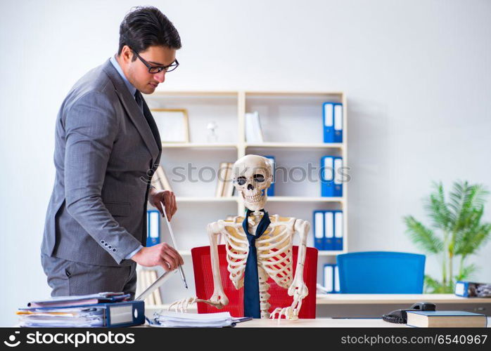 Businessman working with skeleton in office