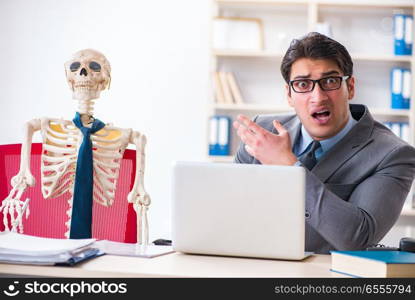 Businessman working with skeleton in office