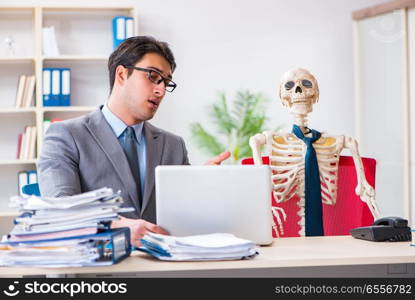 Businessman working with skeleton in office