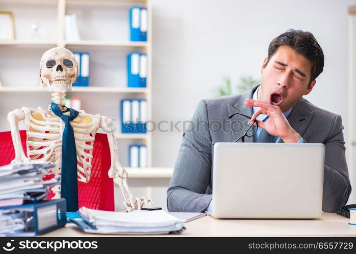 Businessman working with skeleton in office