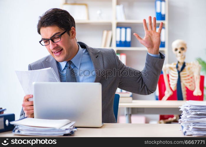 Businessman working with skeleton in office