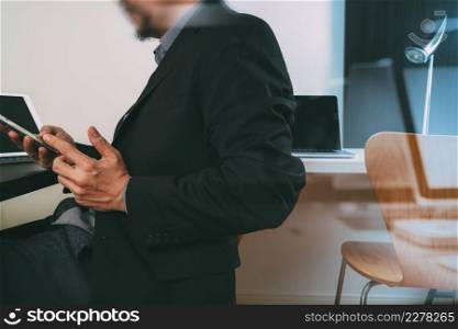 businessman working with smart phone and digital tablet and laptop computer in modern office with glass reflected view