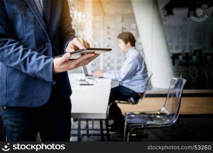 Businessman working with tablet in office, closeup.