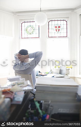 Businessman works from desk in bay window