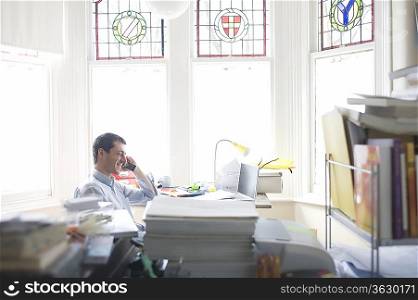 Businessman works from desk in bay window