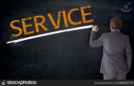 Businessman writes service on blackboard concept.. Businessman writes service on blackboard concept