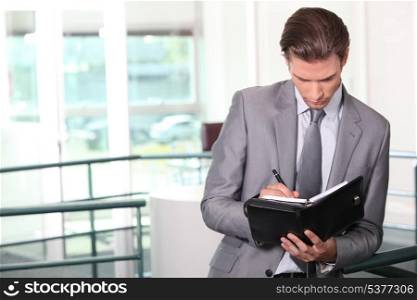 Businessman writing in diary