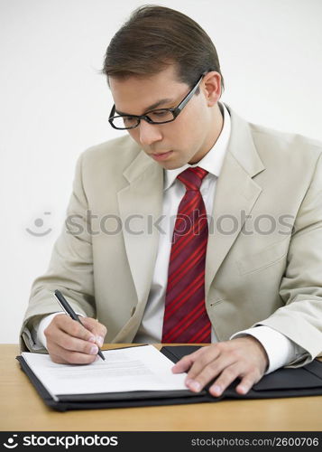 Businessman writing on a document