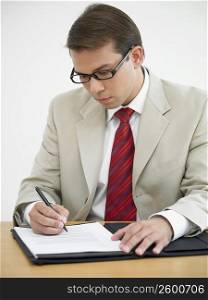 Businessman writing on a document