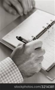 Businessman writing on a spiral notebook