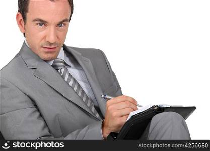 Businessman writing on an organizer