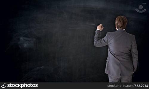 Businessman writing on blackboard concept.. Businessman writing on blackboard concept