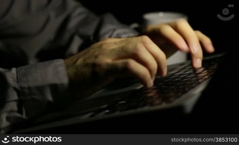 Businessman writing on his personal computer late at night.After hours working man in the office.Writer writes his last novel.Good for a corporate technology edition.