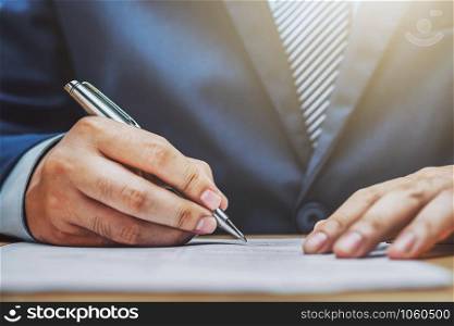 businessman writing on paper report in office