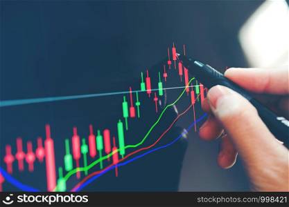 Businessman writing the trading graph of stock market on digital stock market financial exchange and Trading graph