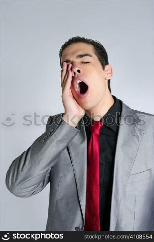 Businessman yawn boring on gray background with suit and red tie