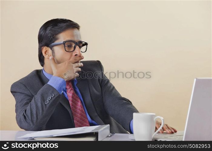 Businessman yawning at desk