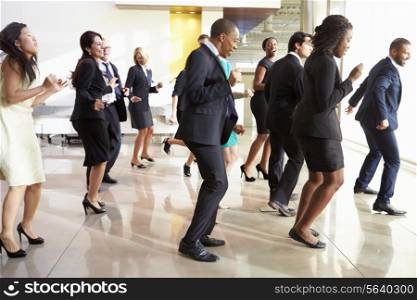 Businessmen And Businesswomen Dancing In Office Lobby