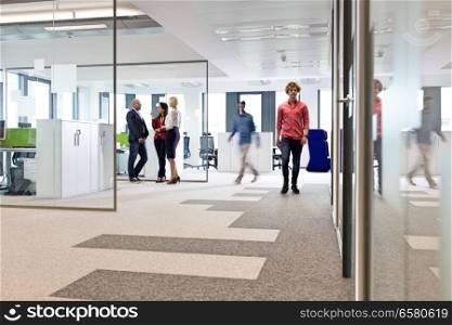 Businessmen and businesswomen in office corridor