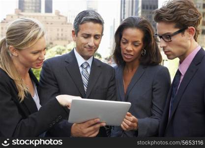 Businessmen And Businesswomen Using Digital Tablet Outside