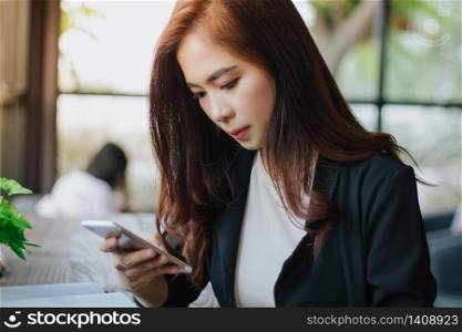 Businessmen and women are using mobile and touch smart phone for Communication and checking on business people in office background