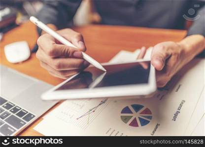 Businessmen are analyzed data from report using smartphone and laptop computer.
