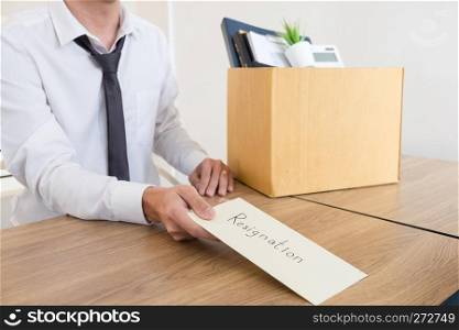Businessmen are holding resignation document and packing personal company on brown cardboard box changing work, unemployment or resign concept.