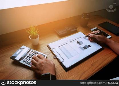 Businessmen calculate the income from the export business on the wood table.Business concept.