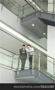 Businessmen Discussing and Pointing on Stairway
