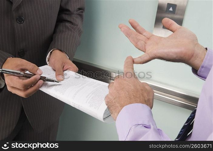 Businessmen discussing in an elevator