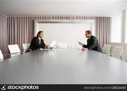 Businessmen Discussing Plans in Conference Room
