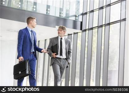 Businessmen discussing while walking at office