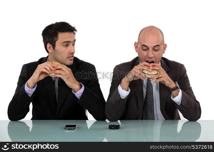 businessmen eating hamburgers