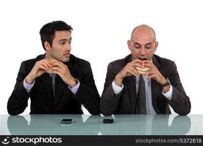 businessmen eating hamburgers
