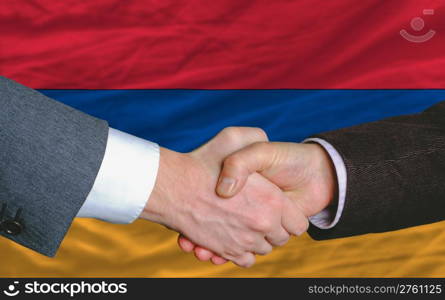 businessmen handshake after good deal in front of armenia flag