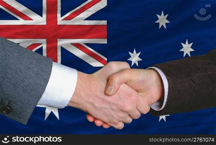 businessmen handshake after good deal in front of australia flag