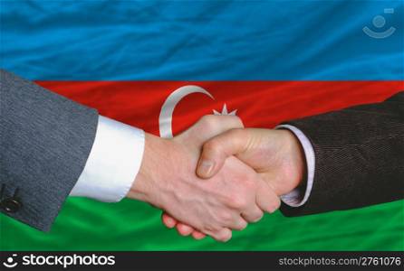 businessmen handshake after good deal in front of azerbaijan flag