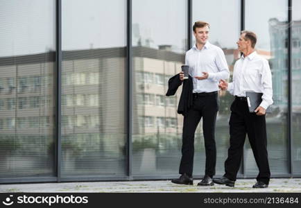 businessmen having conversation while walking