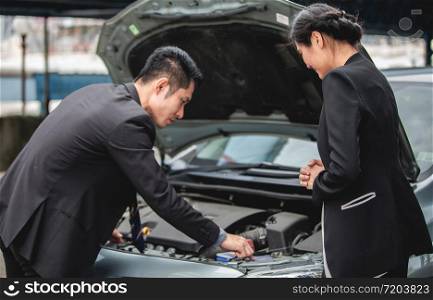 Businessmen help businesswomen check and repair broken cars